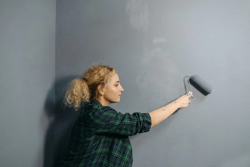 Schilder rolt verf op een binnenwand